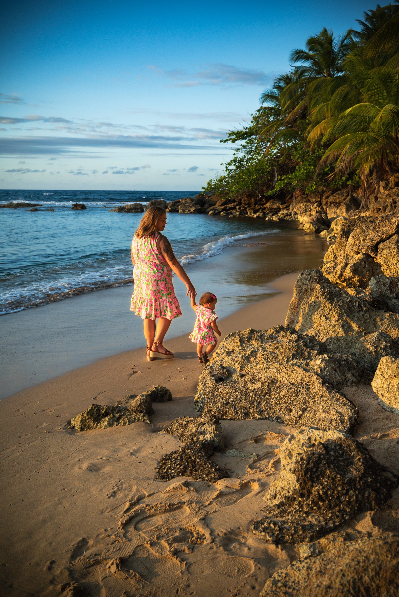 Shyanna walking hand in hand with Emmy along a beach at golden hour